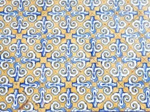 Image of tiles, yellow color with blue color designs, example of what is a repeated texture