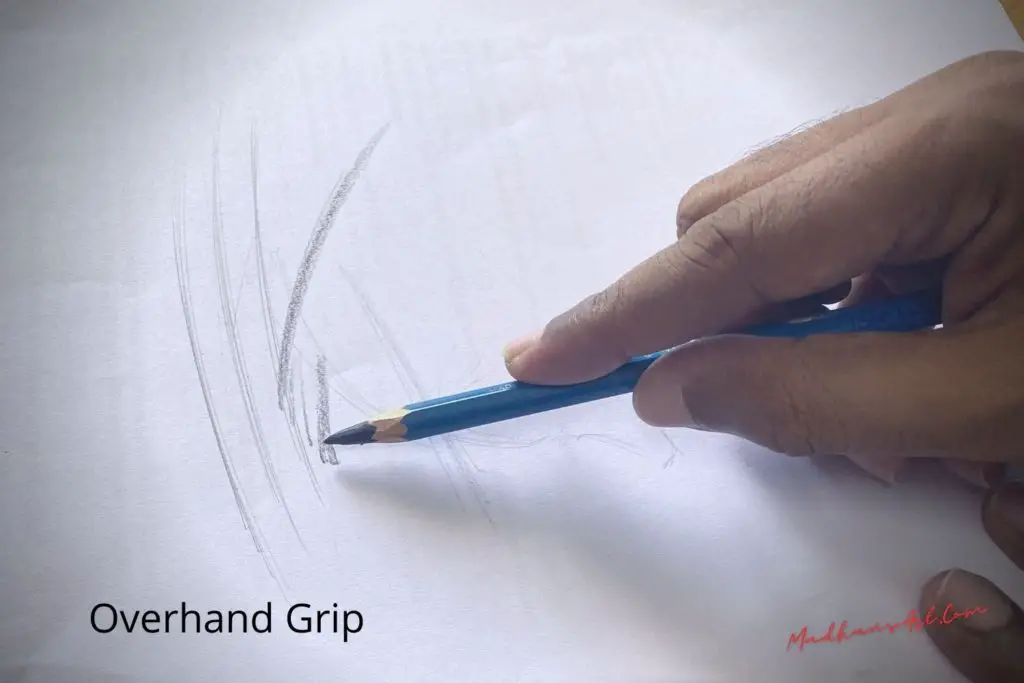 A hand holding a pencil with overhand grip and scribbling, showing how to hold a pencil when drawing