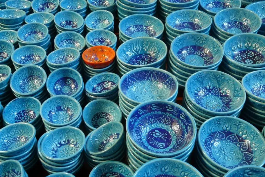 Picture of blue designed Ceramic cups and one red color cup depicting Emphasis