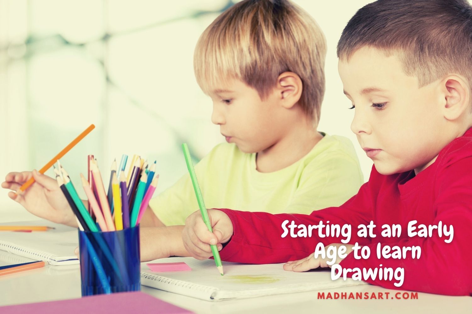 two kids sitting and drawing with color pencil