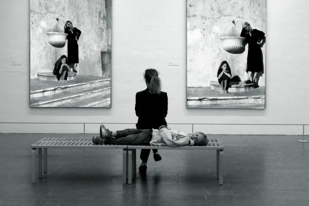 A lady in museum watching two paintings