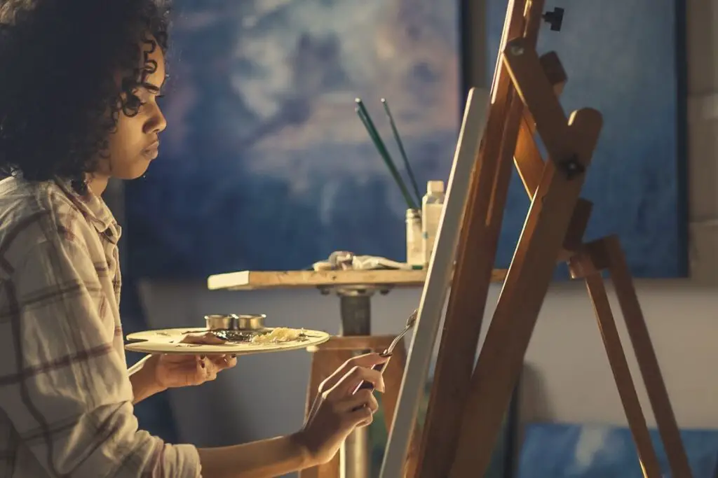 An artist painting on easel depicting art pursued as education