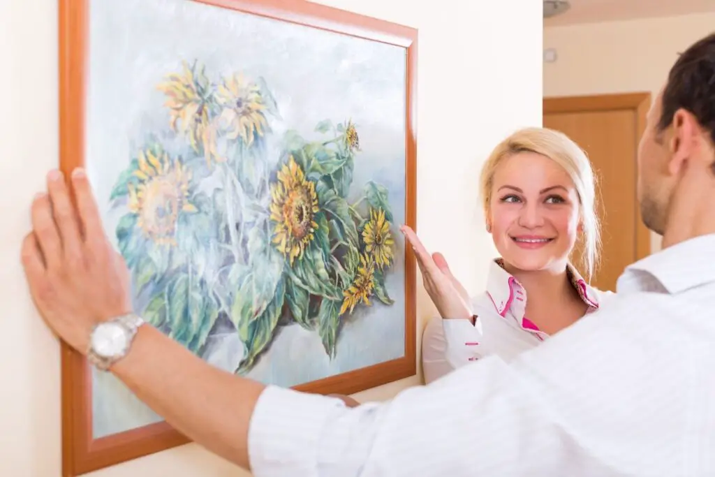 A man placing a patel drawing and a lady smiling at him.