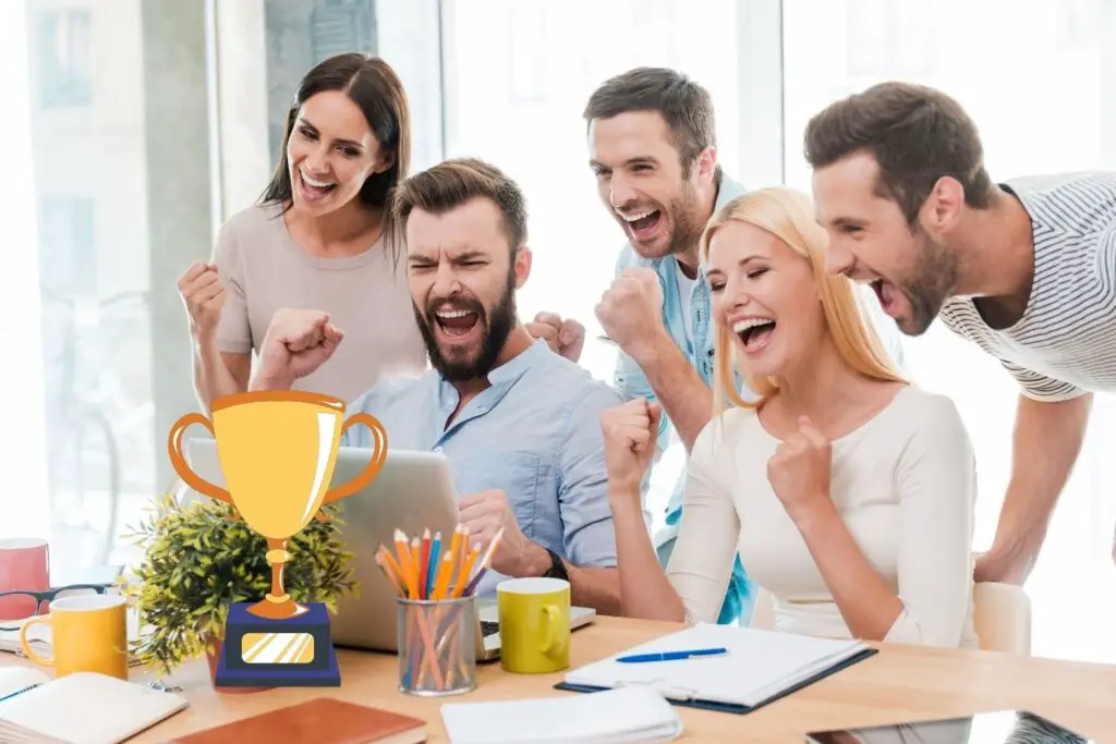 3 men and 2 women screeming in success looking at their laptop.
