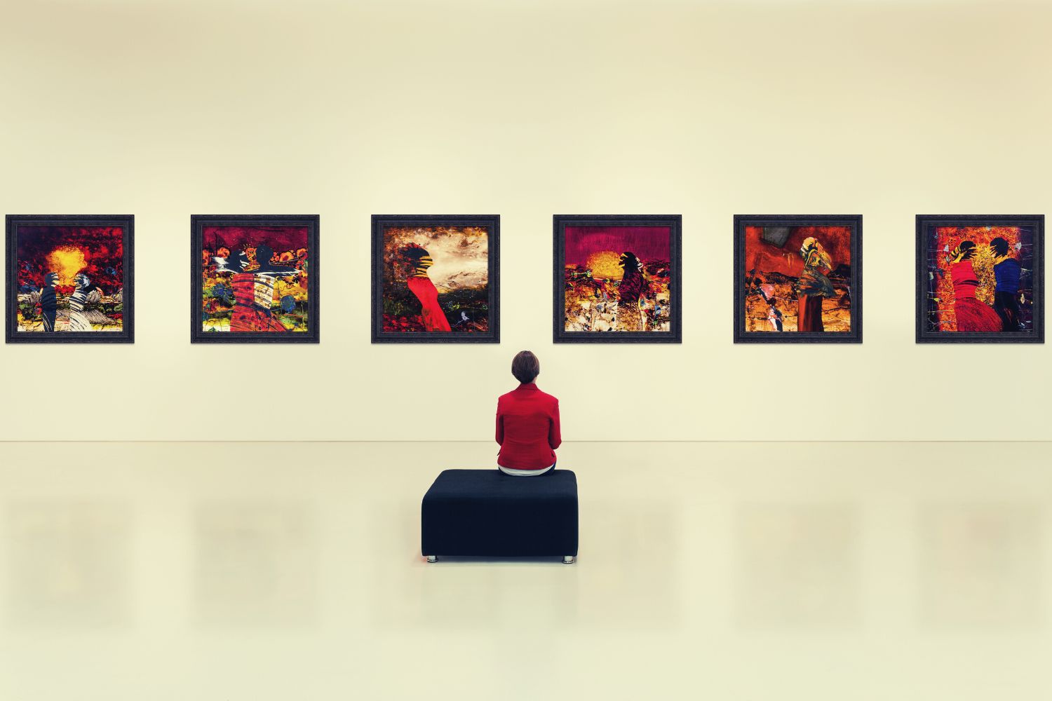 A lady sitting in an art gallery and watching at paintings