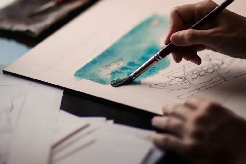 An artist doing a watercolor painting on a drawing